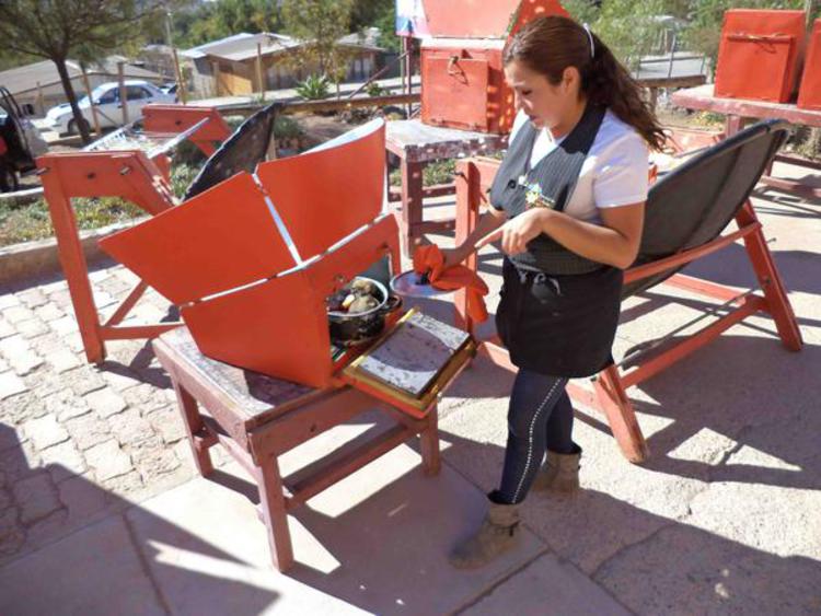 La cuisinière chilienne a besoin d'un torchon pour soulever le couvercle car ça chauffe à l'intérieur du four